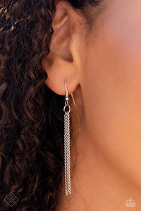 Silver chains hanging from a silver fish hook earring.