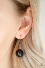 Load image into Gallery viewer, Black bead hanging from a silver fish hook earring.

