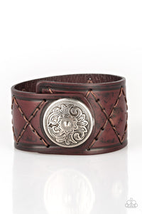 Featuring a flowery silver bead, a thick brown leather band has been stitched in diamond patterns across the front for a rugged look. Features an adjustable snap closure. Sold as one individual bracelet.