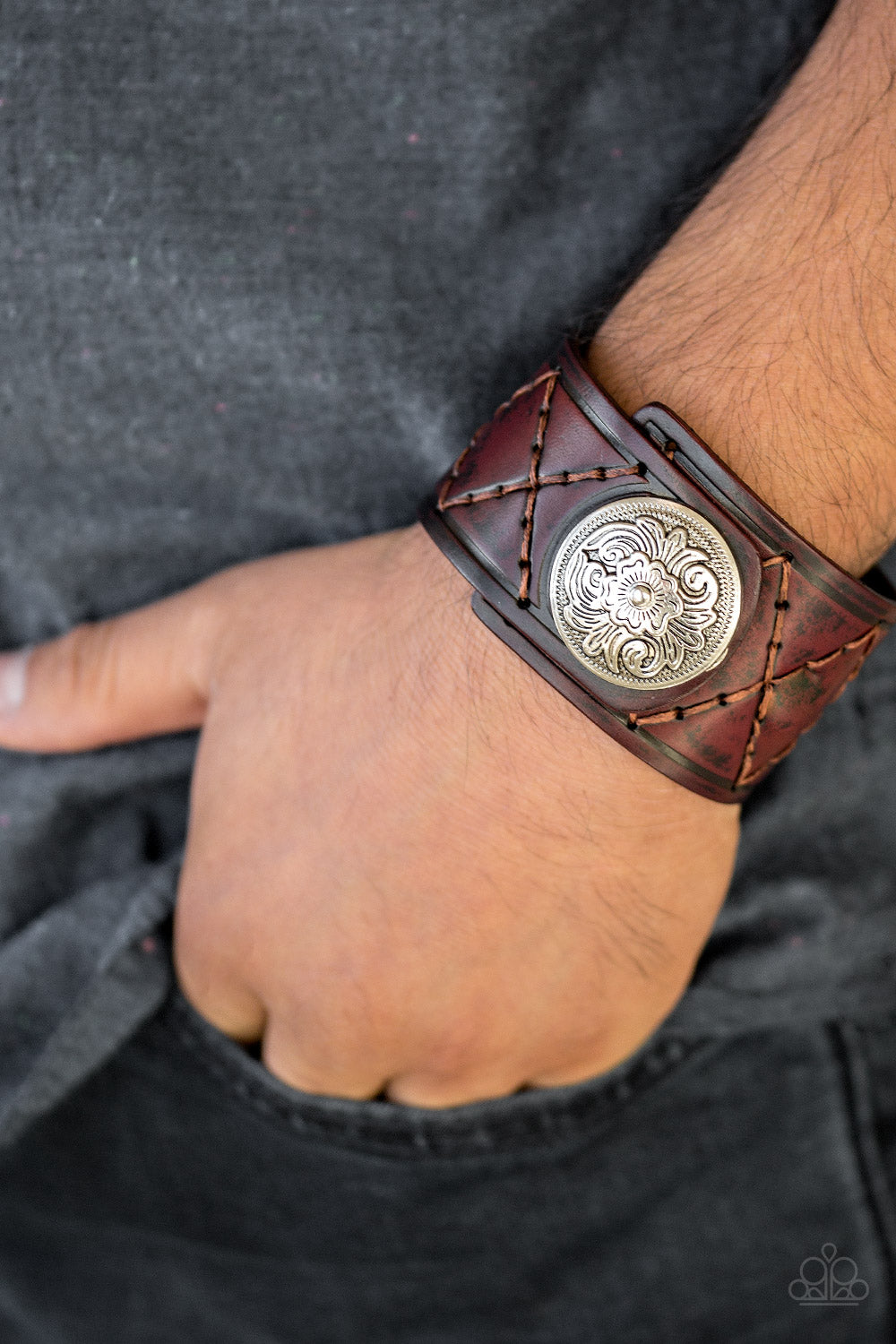 Featuring a flowery silver bead, a thick brown leather band has been stitched in diamond patterns across the front for a rugged look. Features an adjustable snap closure. Sold as one individual bracelet.