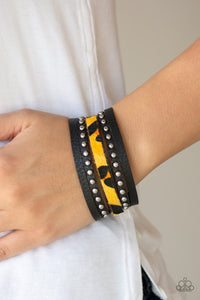 A thick band of black leather has been spliced into layered bands that have been studded and printed in a fuzzy cheetah print for a wild look. Features an adjustable snap closure.  Sold as one individual bracelet.