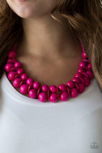 Load image into Gallery viewer, Brushed in a distressed finish, vivacious pink wooden beads and discs join below the collar for a summery look. Features a button loop closure.  Sold as one individual necklace. Includes one pair of matching earrings.
