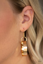 Load image into Gallery viewer, Gold circle hanging from a fish hook earring.
