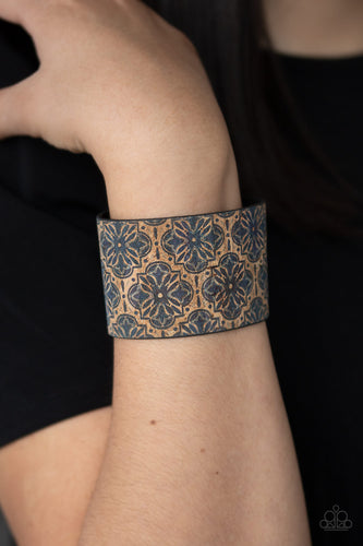 Painted in a regal blue floral pattern, a thick cork-like leather band wraps around the wrist for a statement-making look. Features an adjustable snap closure.  Sold as one individual bracelet.