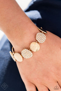 A collection of rounded golden discs wraps around the wrist in a blinding finish. Alternating between rhinestone-encrusted surfaces and strategically textured finishes, the pieces combine to create an elegant statement piece. Features an adjustable clasp closure.