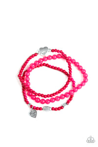 An array of glassy and polished pink beads are threaded along stretchy bands. Infused with silver accents, a collection of silver heart charms and a bead spelling out the word, "love", adorn the beaded strands for a romantic finish.  Sold as one set of three bracelets.