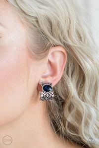 Brushed in an antiqued shimmer, vine-like filigree climbs into a glistening silver hoop. A glittery blue rhinestone is pressed into the top of the frame for a regal finish. Earring attaches to a standard clip-on fitting.  Sold as one pair of clip-on earrings.