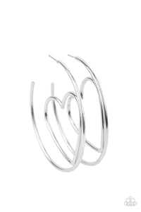 Glistening silver wire delicately bends into an airy heart frame inside a classic silver hoop, creating a flirtatious display. Earring attaches to a standard post fitting. Hoop measures approximately 2" in diameter.  Sold as one pair of hoop earrings.