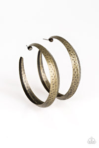 A thick brass hoop creases at the center, creating a chic 3-dimensional display. Finished in a hammered surface, the antiqued design evokes an indigenous inspired style. Earring attaches to standard post fitting. Hoop measures 2 1/4" in diameter.  Sold as one pair of hoop earrings.