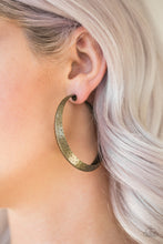 Load image into Gallery viewer, A thick brass hoop creases at the center, creating a chic 3-dimensional display. Finished in a hammered surface, the antiqued design evokes an indigenous inspired style. Earring attaches to standard post fitting. Hoop measures 2 1/4&quot; in diameter.  Sold as one pair of hoop earrings.
