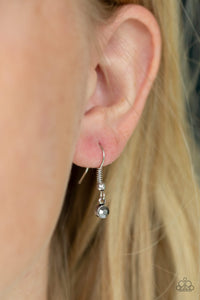Small rhinestone hanging from a fish hook earring.