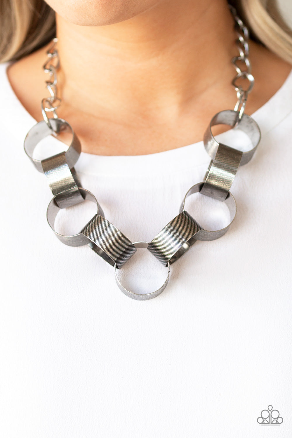 Etched in linear patterns, dramatically oversized silver links connect below the collar for a bold statement-making look. Features an adjustable clasp closure.  Sold as one individual necklace. Includes one pair of matching earrings.