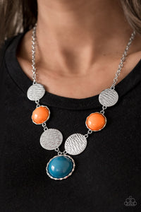 Embossed in wavy textures, shiny silver discs link with bubbly orange and Mosaic Blue beaded frames below the collar, creating a colorful statement piece. Features an adjustable clasp closure.