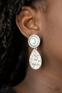 A hammered silver teardrop dangles from the bottom of an ornate silver disc that is dotted with a dreamy opal beaded center. Earring attaches to a standard clip-on fitting. Sold as one pair of clip-on earrings.