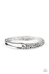 An airy silver fitting links with a silver band encrusted in two rows of glittery hematite rhinestones across the wrist, creating an edgy bangle-like cuff. Features a hinged closure.  Sold as one individual bracelet.