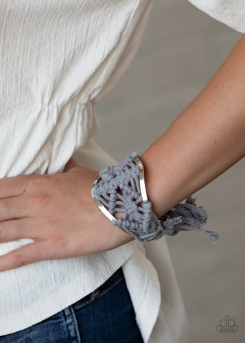 Ash cording decoratively knots and weaves around an airy silver cuff for a macramé inspired look. Knotted around the ends, Ash tassels flair out from the bottoms of the cuff for a wanderlust finish.  Sold as one individual bracelet.