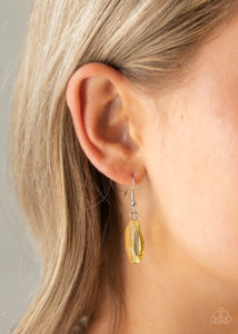 Opaque yellow circle hanging from a silver fish hook earring.