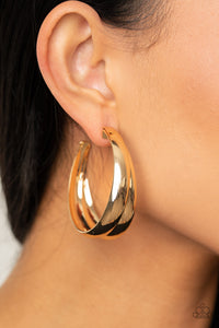 Two thick gold bars delicately overlap into a boldly oversized hoop. Earring attaches to a standard post fitting. Hoop measures approximately 2" in diameter.  Sold as one pair of hoop earrings.