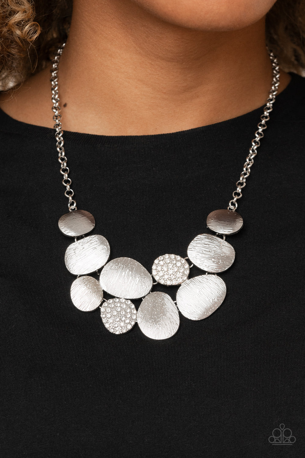 Featuring imperfect oval shapes, a series of delicately scratched and white rhinestone encrusted frames connect into a clustered pendant below the collar for a refined flair. Features an adjustable clasp closure.  Includes one pair of matching earrings.