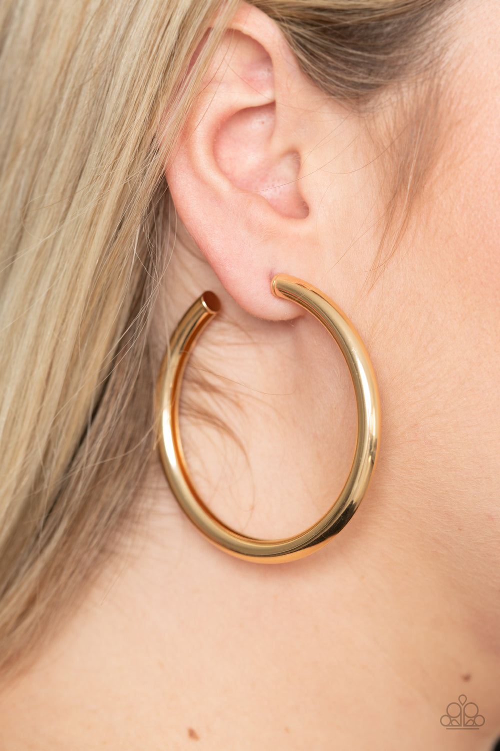 A thick gold bar delicately curls into a glistening oversized hoop for a retro look. Earring attaches to a standard post fitting. Hoop measures approximately 2 1/4