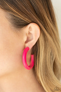 Painted in a flamboyant Pink Peacock finish, a thick wood hoop curls around the ear for a flirtatiously colorful look. Earring attaches to a standard post fitting. Hoop measures approximately 2" in diameter.  Sold as one pair of hoop earrings.