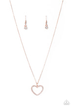 Load image into Gallery viewer, Encrusted in sparkly white rhinestones, an airy rose gold heart frame swings from a dainty rose gold chain below the collar for a romantic look. Features an adjustable clasp closure. Sold as one individual necklace. Includes one pair of matching earrings.
