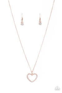 Encrusted in sparkly white rhinestones, an airy rose gold heart frame swings from a dainty rose gold chain below the collar for a romantic look. Features an adjustable clasp closure. Sold as one individual necklace. Includes one pair of matching earrings.