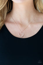 Load image into Gallery viewer, Encrusted in sparkly white rhinestones, an airy rose gold heart frame swings from a dainty rose gold chain below the collar for a romantic look. Features an adjustable clasp closure.  Sold as one individual necklace. Includes one pair of matching earrings.
