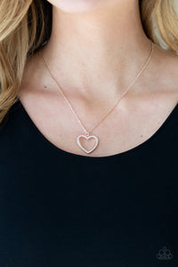 Encrusted in sparkly white rhinestones, an airy rose gold heart frame swings from a dainty rose gold chain below the collar for a romantic look. Features an adjustable clasp closure.  Sold as one individual necklace. Includes one pair of matching earrings.