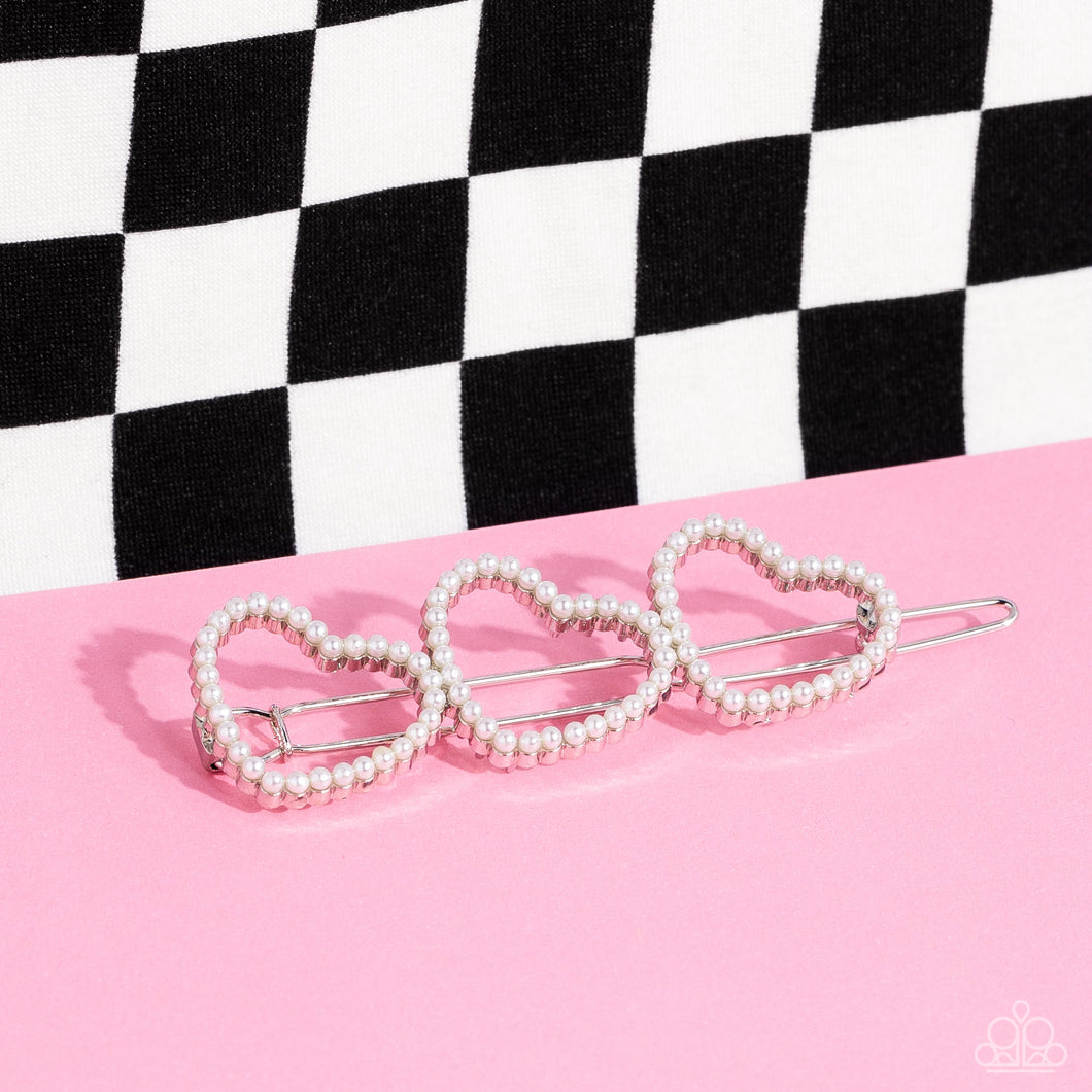 Dainty white pearls adorn a trio of silver heart silhouette frames, creating a romantic display. Features a clamp barrette closure.  Sold as one individual barrette.