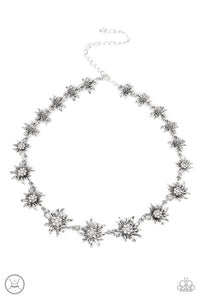 Featuring studded silver or white rhinestone encrusted centers, lifelike silver daisies gradually increase in size as they link around the necklace for a fashionably floral display. Features an adjustable clasp closure.  Sold as one individual choker necklace. Includes one pair of matching earrings.