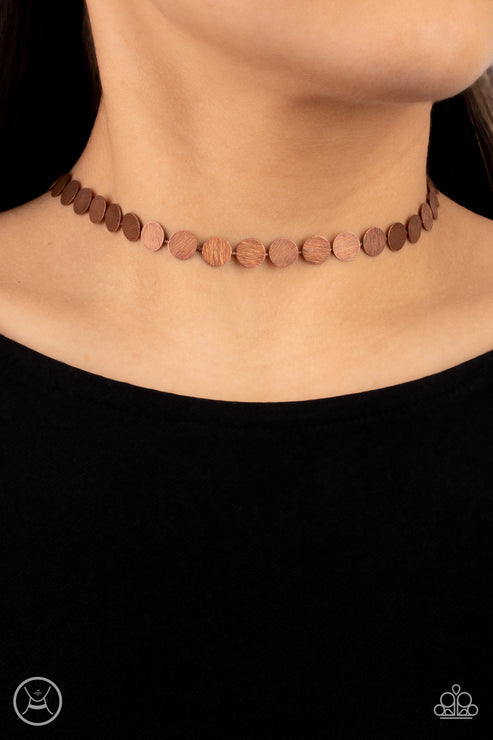 Delicately scratched in a blinding shimmer, a row of dainty copper discs shines around the neck for a minimalistic sheen. Features an adjustable clasp closure.  Sold as one individual choker necklace. Includes one pair of matching earrings.