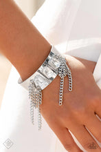 Load image into Gallery viewer, A thick, industrial silver cuff is topped by three brilliant white, emerald-cut gems. Strands of silver curb chain stream from each side of the trio of glitz, adding undeniable drama and eye-catching movement to the piece.
