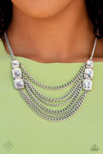 Load image into Gallery viewer, Layers of thick, silver curb chain drape across the chest, creating a fierce, industrial statement piece. Three blinding white, emerald-cut gems that gradually increase in size, are affixed to each side of the swooping chains, adding dramatic sparkle to the collision of grit and glitz. Features an adjustable clasp closure. Includes one pair of matching earrings.
