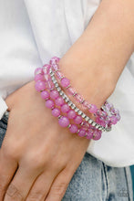 Load image into Gallery viewer, A mismatched assortment of lavender and orchid beads stacks together with a strand of sparkling white rhinestones set in square fittings. The varying opacities of the glassy beads adds depth and dimension to the colorful layers, as subtle floral beads set between them add hints of metallic sheen. Set of four bracelets.
