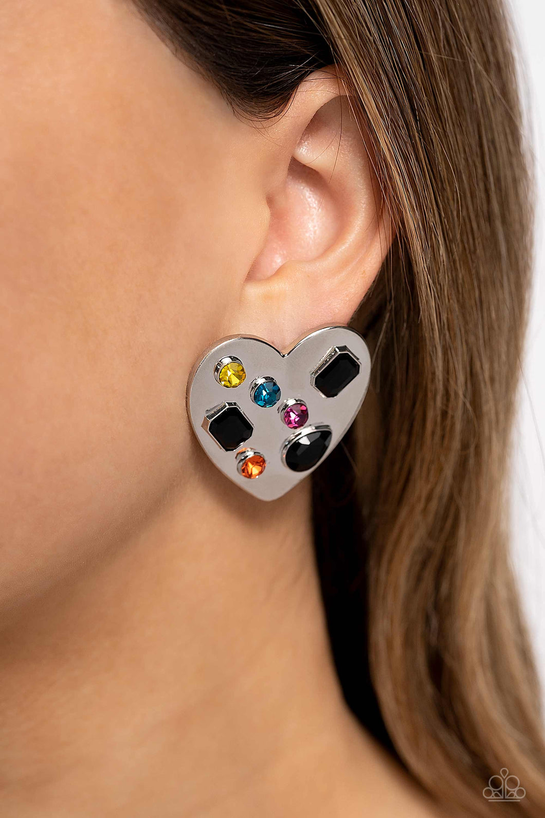 Brushed with shimmery pink, orange, yellow, blue, and black round, teardrop and emerald-cut gems, an oversized, high-sheen silver heart frame rests against the ear for a dazzling finish. Earring attaches to a standard post fitting.  Sold as one pair of post earrings.