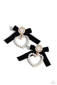 A solitaire white pearl, pressed in a white rhinestone-encrusted gold hoop, gleams atop a pearl-dotted heart frame resulting in a dazzling statement piece. A black velvet ribbon fans out from the pearly centerpiece further infusing the design with elegance. Earring attaches to a standard post fitting.  Sold as one pair of post earrings.