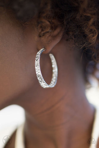 The front facing surface of a chunky silver hoop is dipped in brilliantly sparkling rhinestones while light-catching texture wraps around the back. The interior of the hoop features the opposite pattern, creating the illusion of a full hoop of blinding Blockbuster rhinestones. Earring attaches to a standard post fitting. Hoop measures 1 3/4