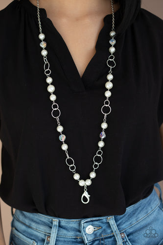 A refined collection of glassy white gems, textured silver rings, and pearly white beads drape across the chest for a timeless look. A lobster clasp hangs from the bottom of the design to allow a name badge or other item to be attached. Features an adjustable clasp closure.  Sold as one individual lanyard. Includes one pair of matching earrings.